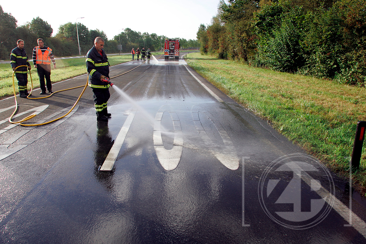 Winnende foto FotoGamma Leuven. Brummense brandweermensen spuiten de N-348 schoon nadat een Belgische vrachtwagen een deel van zijn lading slib was verloren ter hoogte van de rotonde bij Brummen.